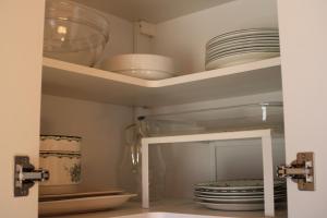 a cupboard with plates and dishes in it at Comfortable and cozy cottage in Sysslebäck +19 photos