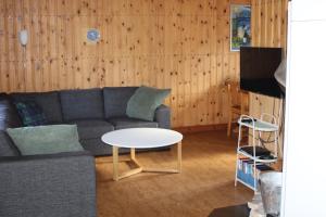 a living room with a couch and a table at Comfortable and cozy cottage in Sysslebäck