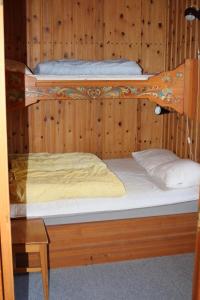 two bunk beds in a wooden walled room at Comfortable and cozy cottage in Sysslebäck