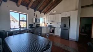 a kitchen with a table and a kitchen with white cabinets at Shelley Point Townhouse in Stompneusbaai
