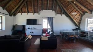 a living room with couches and a dining room at Shelley Point Townhouse in Stompneusbaai