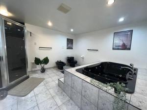 a large bathroom with a tub and a shower at Luxury comforts getaway home in Brossard