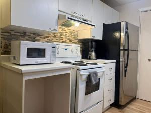 a kitchen with a microwave and a stove top oven at Luxury comforts getaway home in Brossard