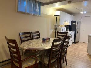a dining room table with chairs and a kitchen at Luxury comforts getaway home in Brossard