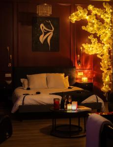 a bedroom with a bed and a table in front of it at Suite romantique avec Balneo et jeux coquins in Roanne