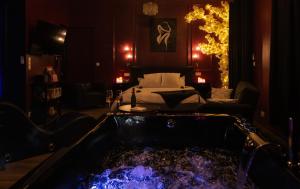 a room with a tub in the middle of a room at Suite romantique avec Balneo et jeux coquins in Roanne