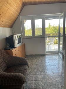 a living room with a couch and a tv at VIL'LAGUNA Apartment with view of Balaton in Zánka