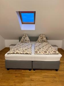 ein Bett mit zwei Kissen darauf in einem Zimmer in der Unterkunft Villa Barte nähe Outlet Parndorf in Pachfurth