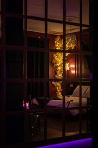 a view of a bedroom through a window at night at Suite romantique avec Balneo et jeux coquins in Roanne
