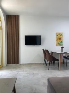 a living room with a flat screen tv on a wall at Santorini Drimadh Apartment in Gjilek