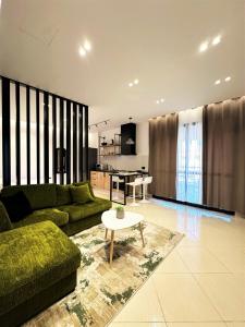 a living room with a green couch and a table at DuoNest Gray Loft Studio in Tirana