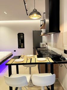 a kitchen with a table and two white chairs at DuoNest Gray Loft Studio in Tirana +3 photos