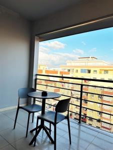 a balcony with a table and two chairs and a window at DuoNest Gray Loft Studio in Tirana