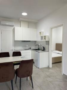 a kitchen with a table and chairs and a bed at Santorini Drimadh Apartment in Gjilek