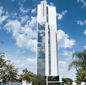 a tall white building with a sign on it at Prime Flats in Palmas