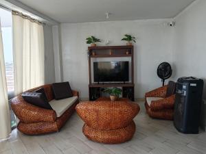 a living room with three chairs and a television at VistamarGrau in Caleta Grau