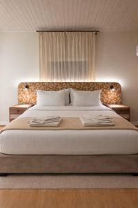 a bedroom with a large bed with two towels on it at Pine View Boutique Hotel Adults Only in Troodos +30 photos