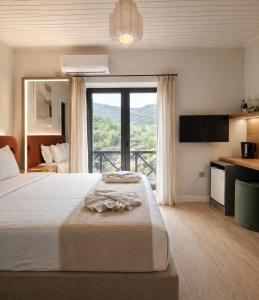 a bedroom with a large bed and a large window at Pine View Boutique Hotel Adults Only in Troodos