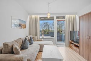 a living room with a couch and a tv at Berolina C 106 in Dahme