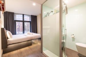 a bathroom with a bench in front of a window at easyHotel Birmingham in Birmingham