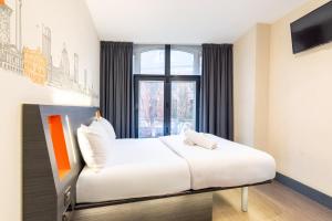 a hotel room with a bed and a window at easyHotel Birmingham in Birmingham