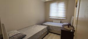 two beds in a small room with a window at Bıyıklı House in Akcaabat