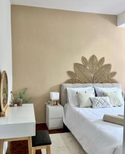 a bedroom with a white bed with a large plant on the wall at Meu Quintal 4, Calheta-Madeira in Calheta