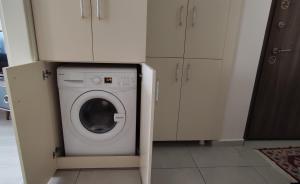 a washer and dryer in a kitchen with white cabinets at Bıyıklı House in Akcaabat +16 photos