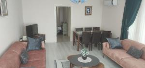 a living room with couches and a table and a dining room at Bıyıklı House in Akcaabat