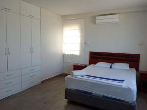 a bedroom with a bed and white cabinets at VistamarGrau in Caleta Grau +26 photos