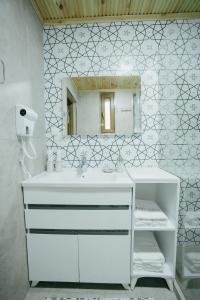 a white bathroom with a sink and a mirror at Imranbek Boutique Hotel in Bukhara +125 photos