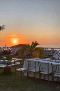 a table and chairs with the sunset in the background at VistamarGrau in Caleta Grau
