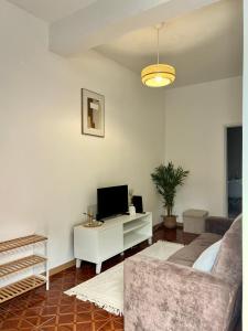 a living room with a couch and a tv at Meu Quintal 4, Calheta-Madeira in Calheta