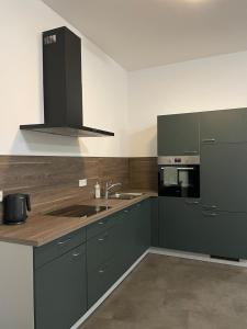 a kitchen with green cabinets and a sink and a stove at Ferienwohnung Alina in Werne an der Lippe