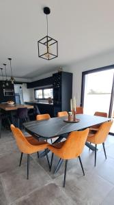 a dining room with a black table and chairs at Location maison confortable et cozi in Cazaux