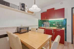 a kitchen with a wooden table and red cabinets at Berolina C 106 in Dahme