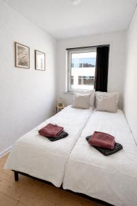 a bedroom with a large white bed with two towels on it at Hyggelig, lys og centralt lejlighed in Esbjerg