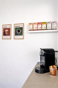 a counter with a coffee maker and pictures on a wall at Hyggelig, lys og centralt lejlighed in Esbjerg +9 photos