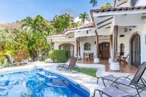 a villa with a swimming pool and a house at Villa Sandy en Samara Rocks in Sámara