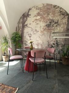 a dining room with a table and pink chairs at Ledro Lake Suites in Ledro
