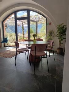 a table and chairs in a room with a large window at Ledro Lake Suites in Ledro +155 photos