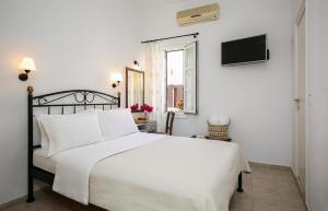 a bedroom with a white bed and a window at Panorama Hotel in Naxos Chora +38 photos