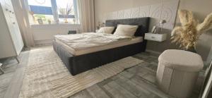 a bedroom with a bed and a chair at Ferienwohnung Schmuckstück in Wolfshagen +26 photos