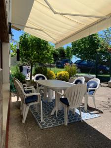 a white table and chairs under an umbrella at MyG-BarriAlto in Cirueña