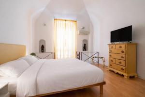 a bedroom with a bed and a dresser with a television at Palazzo Barone in Bari