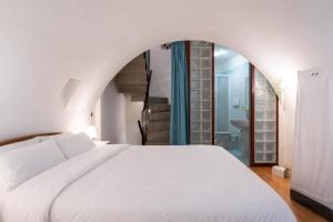 a bedroom with a white bed and a bathroom at Palazzo Barone in Bari