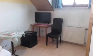 Zimmer mit einem Schreibtisch mit Stuhl und einem Computer in der Unterkunft Gasthaus Bethlehem in Dornbirn