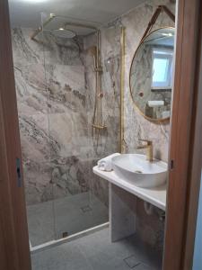 a bathroom with a sink and a shower with a mirror at Apartman Golden Stone in Ivanica +21 photos
