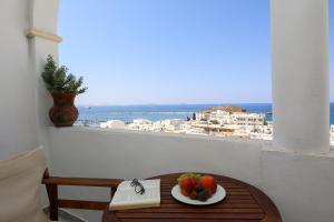 a table with a plate of fruit on a balcony at Panorama Hotel in Naxos Chora