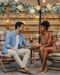a man and woman sitting at a table with a bottle of wine at L'Eure de Luxure Loveroom Suite in Normandy in Évreux